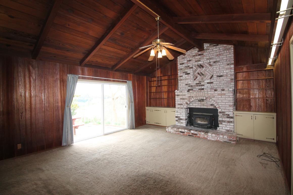 Living room with vaulted ceiling and brick surround fireplace